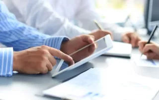 Two people looking at a tablet with financial statements.