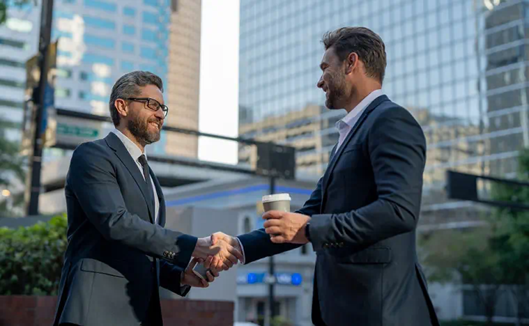 American businessman shaking hands with partner. Businessmen in suit shaking hands outdoors. Handshake between two businessmen. wo business men had business contacts. Business strategy.