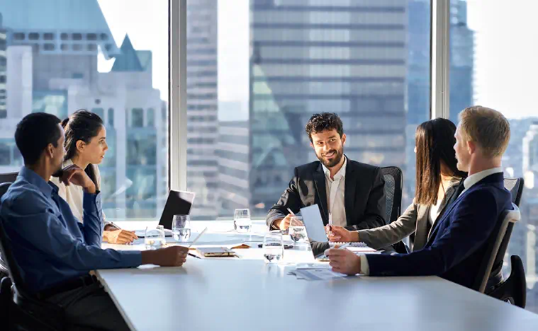 diverse executive colleagues people discussing financial project working together in office at group meeting table in corporate board room.