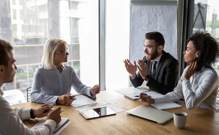 Serious multi-ethnic business entities gathered together for negotiating meeting
